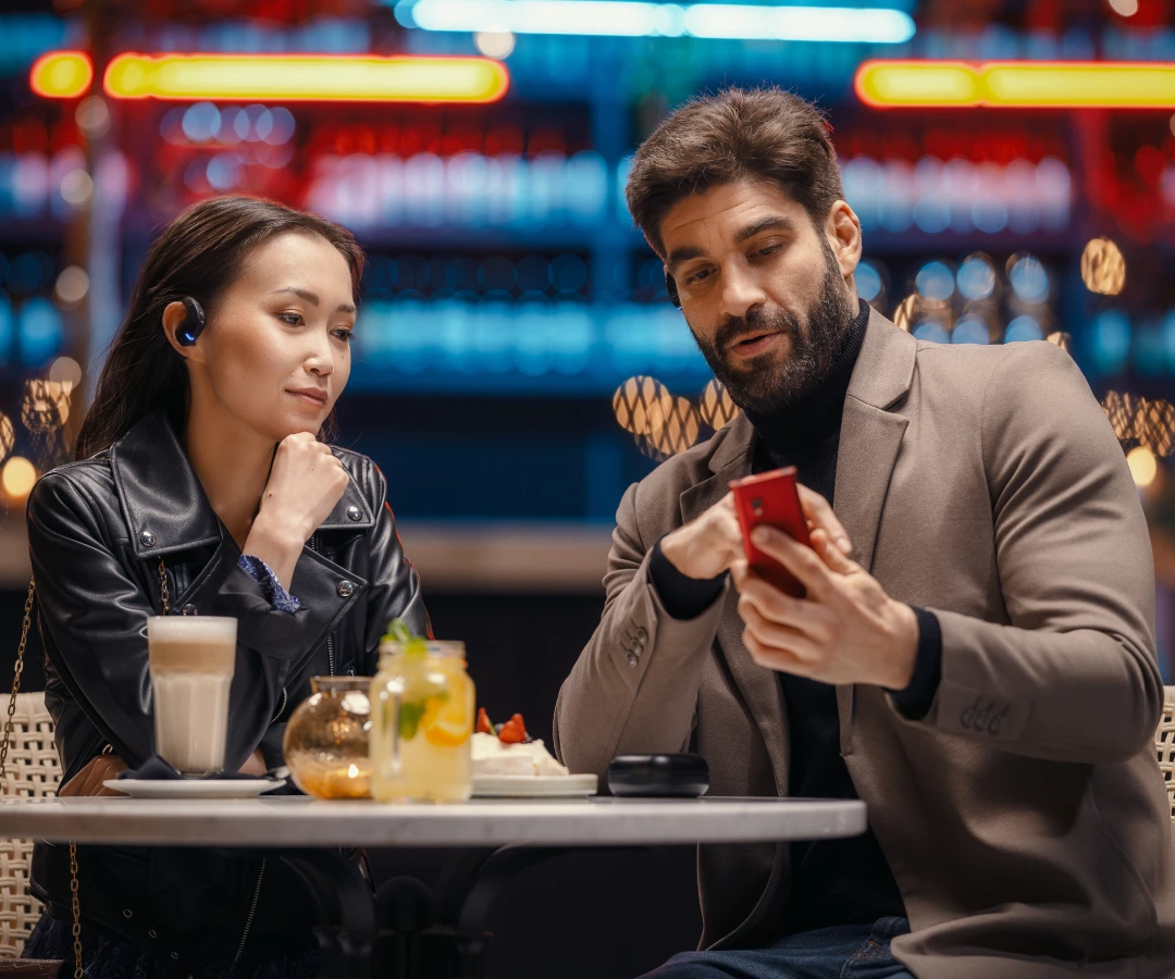 dwoje nieznajomych w restauracji miło gawędzących przy użyciu Vasco Translatora
